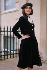 a lady in a black velvet jacket and skirt